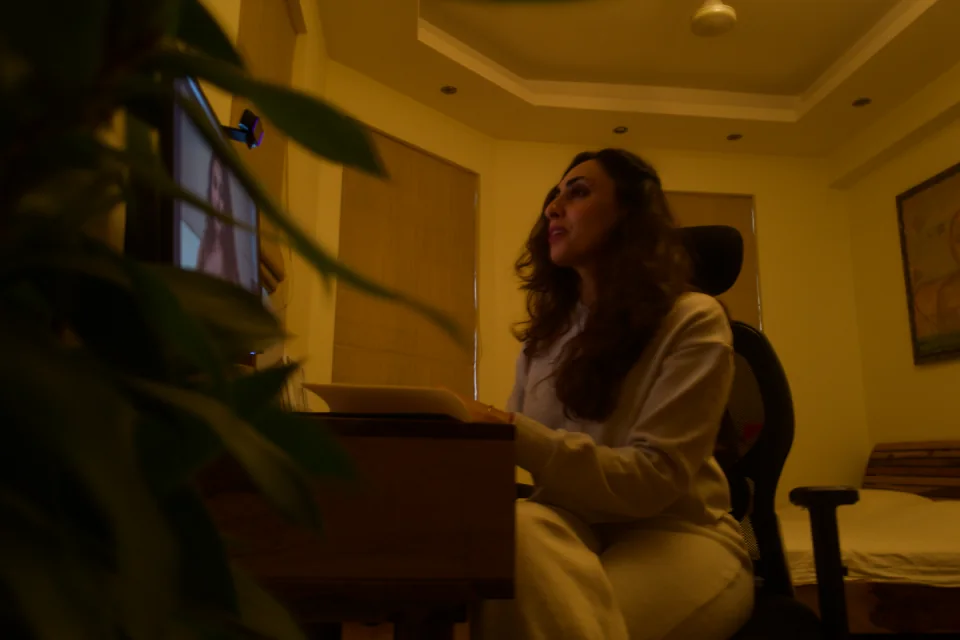 Sabah seated at her laptop in her work space