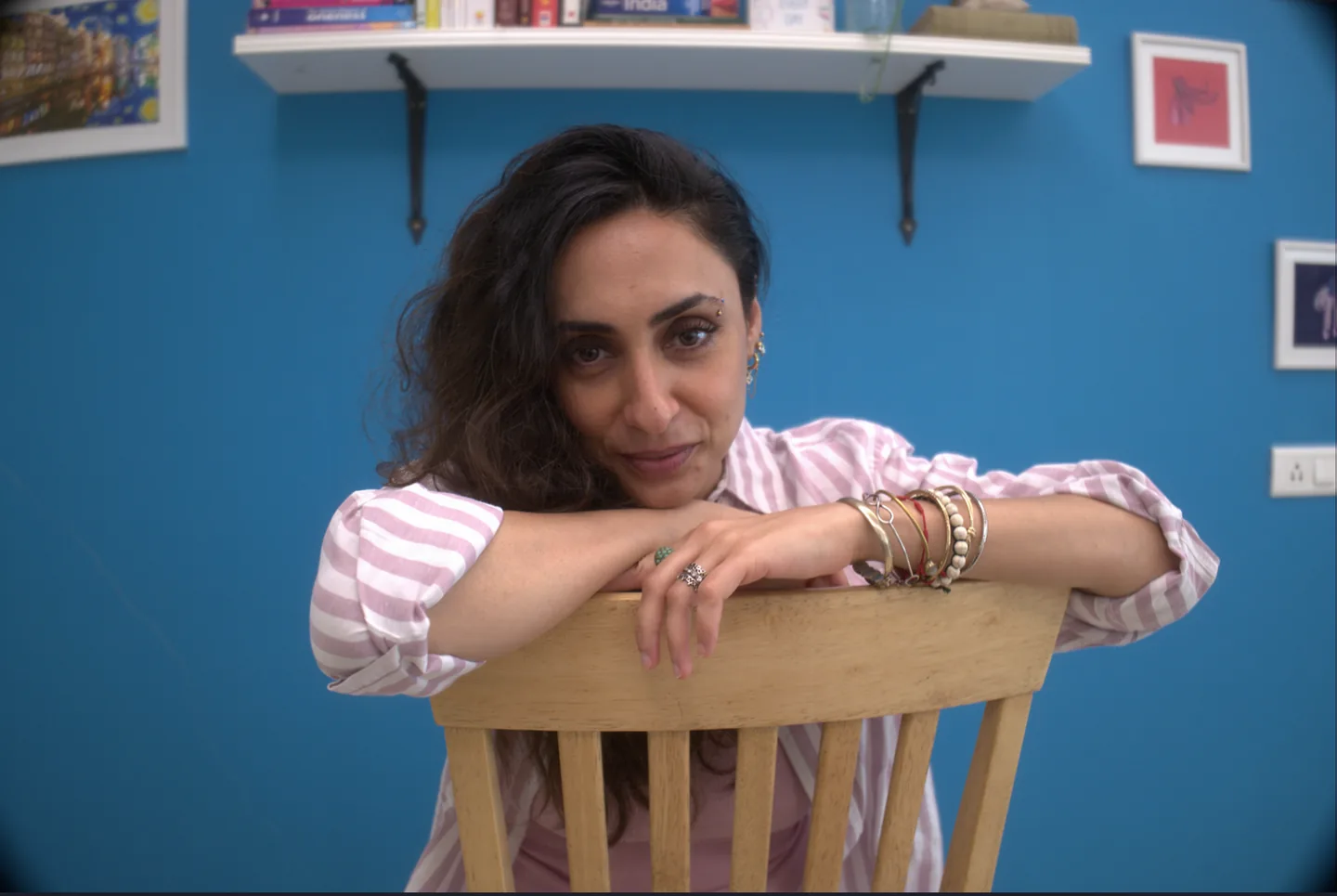 Sabah leaning over a wooden chair in her study