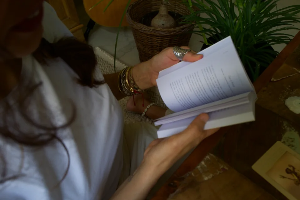 An overhead view of Sabah reading beside her plants