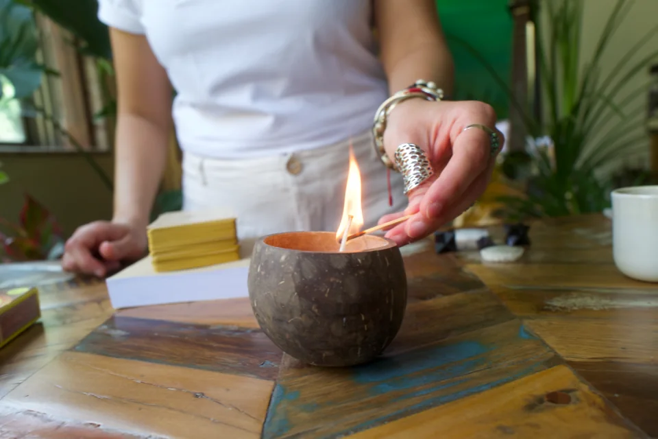 Sabah lighting a small flame on a wooden table
